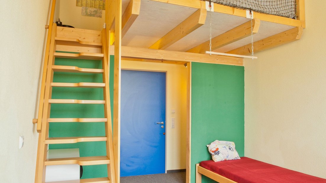 Phòng trong ngôi nhà trên đồng cỏ có giường và cầu thang gỗ